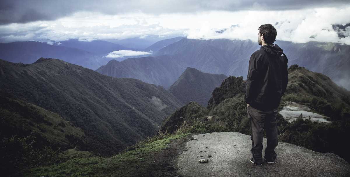 A man looks out at the Andes Mountains as he hikes to Machu Picchu