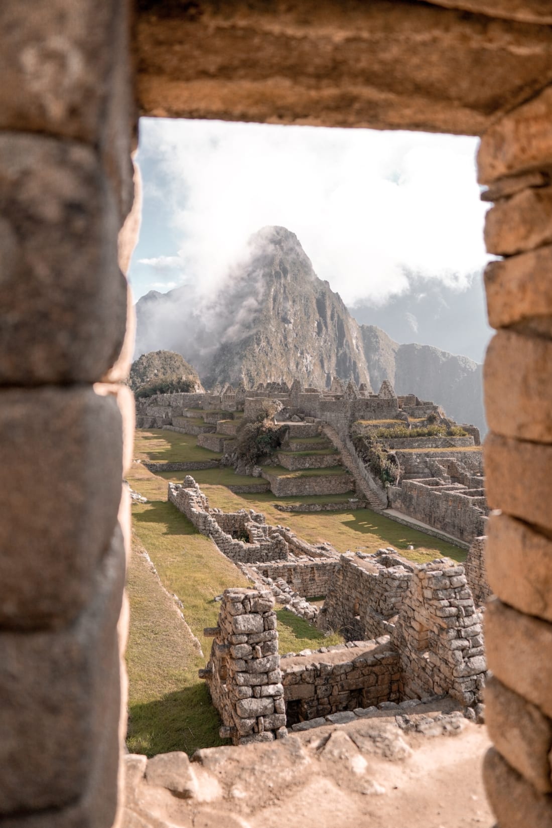 A photograph of Machu Picchu taken from inside a doorway at the citadel