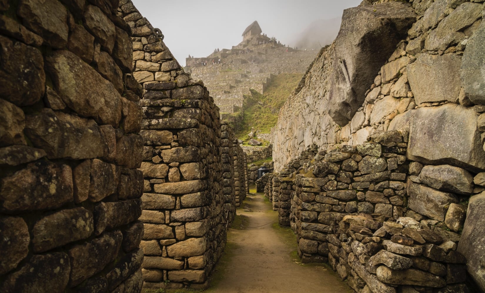 A photograph taken inside some stony ruins at the Machu Picchu site, looking down a hallway