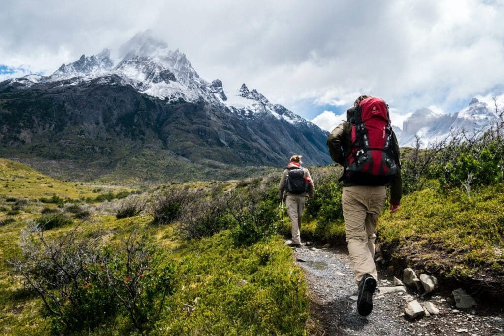 Two hikers trekking mountain path on Torres del Paine W Trek