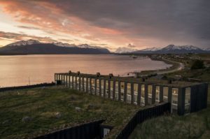 A photograph of Remota Hotel in Puerto Natales, Chile taken in the early evening. Última Esperanza Sound is in the background. Remota is an excellent starting point for adventures into Torres del Paine National Park