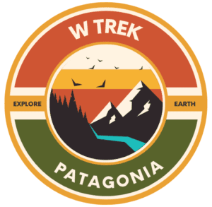 A logo for the W Trek hiking adventure in Patagonia with The Explorer's Passage. The circular logo is light green and orange and features a sunset over the mountains of Torres del Paine National Park in Chile
