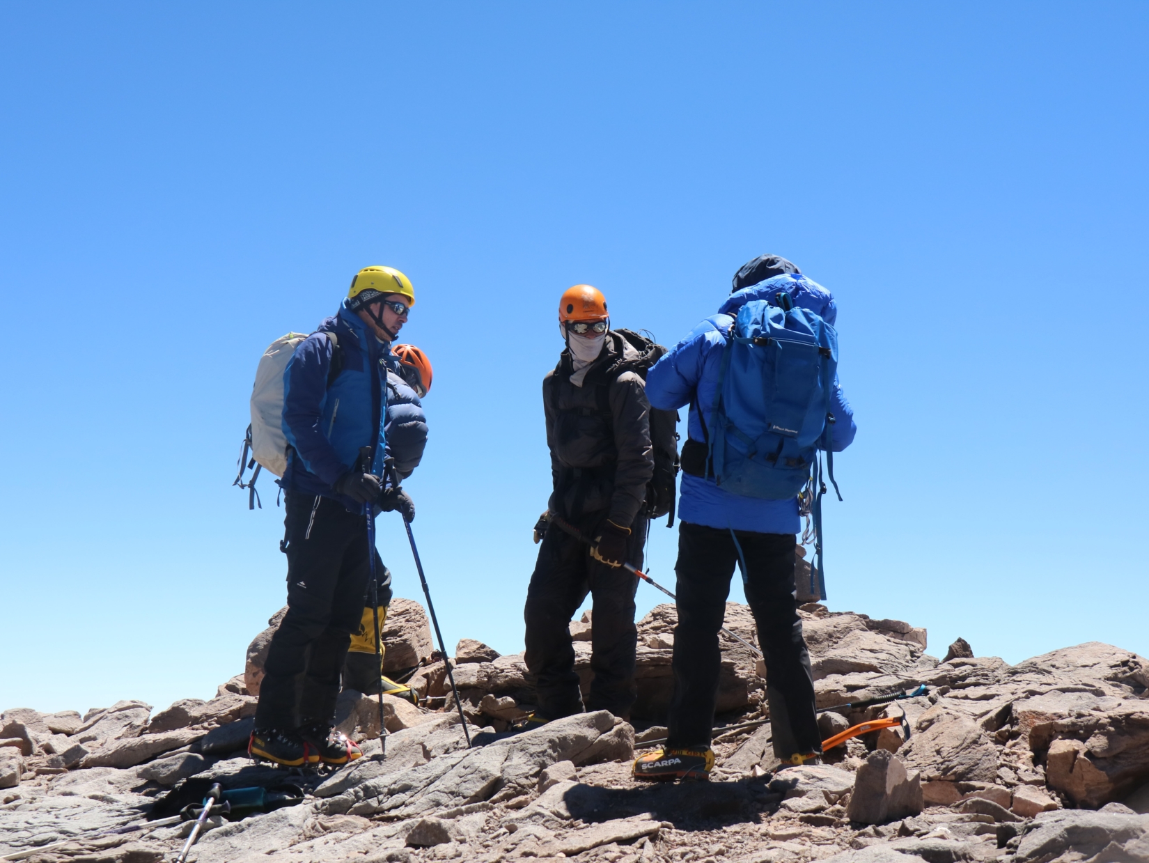 Three trekkers during the daytime on top of a mountain 