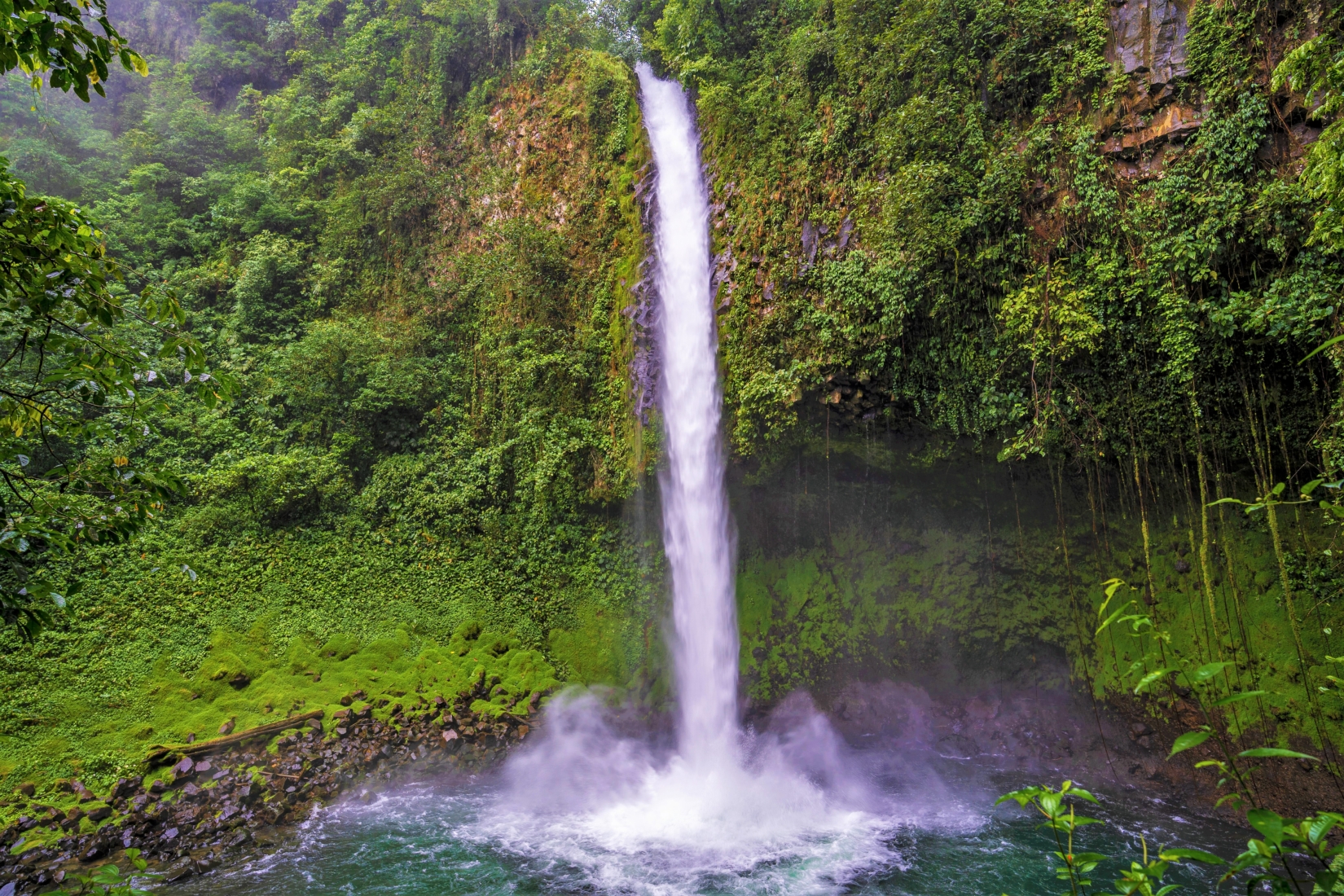 Water surging down the La Fortuna Waterfall into a body of water in Costa Rica