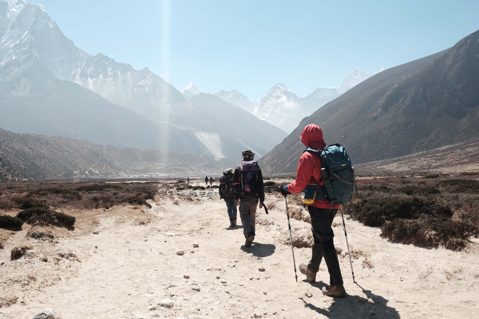 Several hikers with backpacks trekking on the trail to Everest Base Camp in Nepal