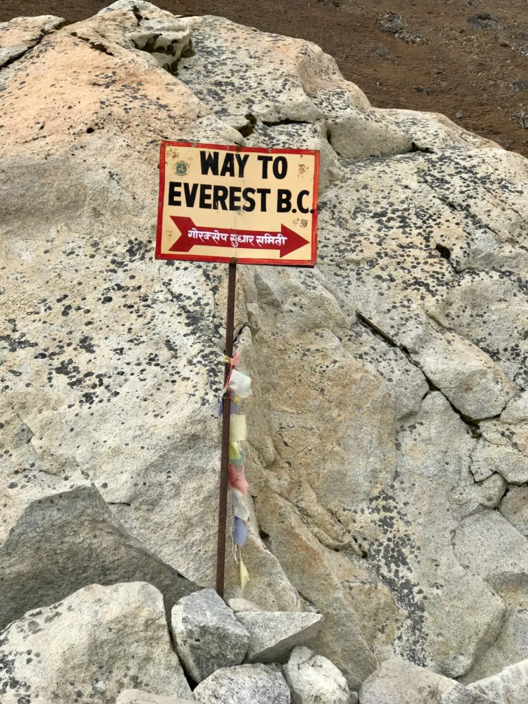A picture of a sign on the trail to Everest Base Camp. The sign reads Way to Everest B.C. with a red arrow