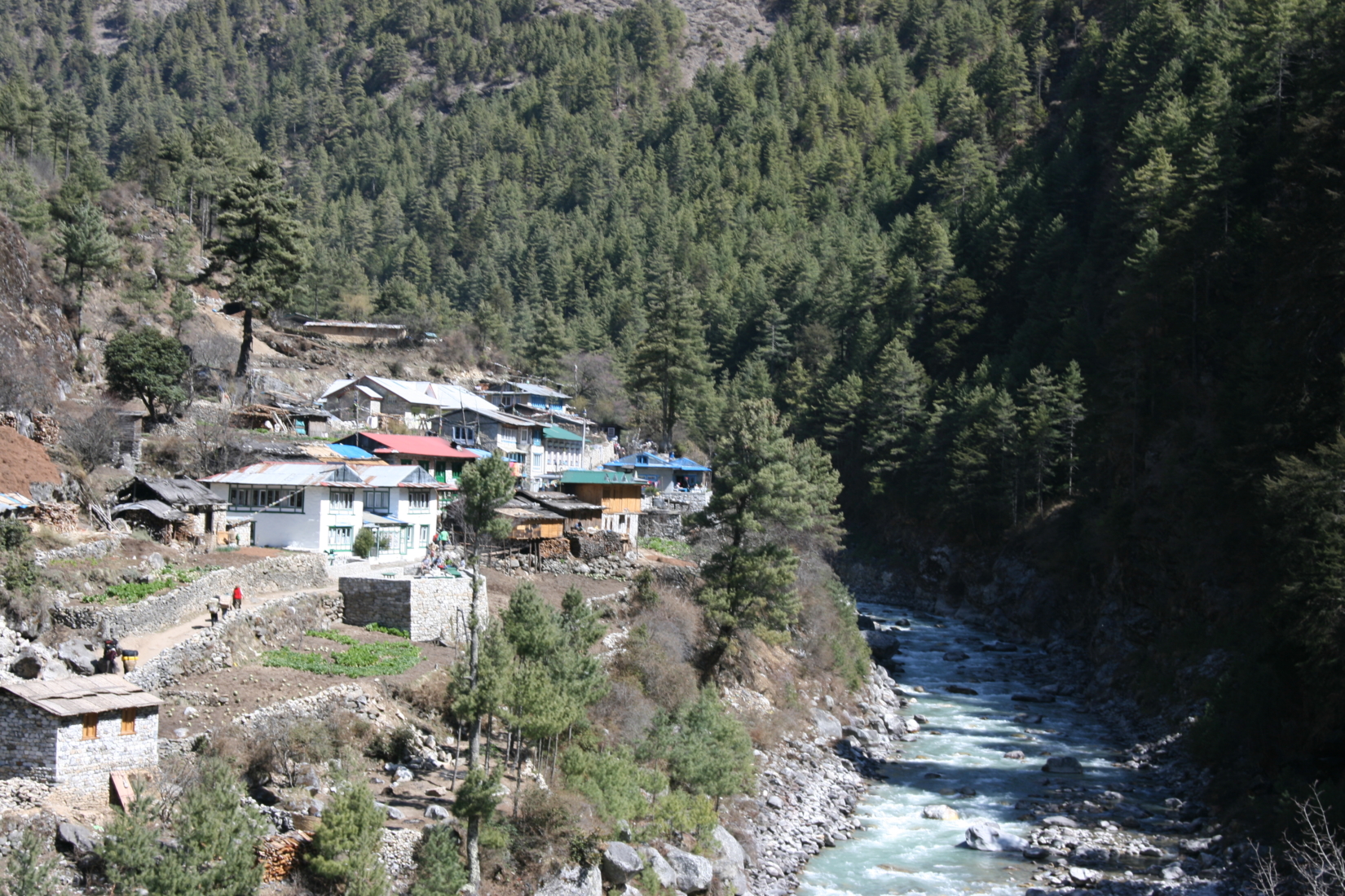 A small Nepalese village sits on a small hill overlooking the Dhudh Kosi river below