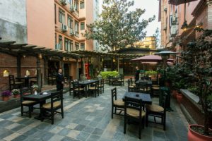 A photograph of the outdoor courtyard and dining area at Hotel Marshyangdi in Kathmandu, Nepal