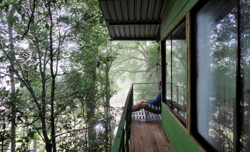 Man sitting on balcony looking at rainforest on the Osa Peninsula
