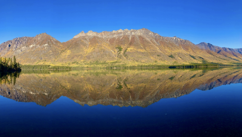 Reflection of mountains on Annie Lake, an alpine lake in the Yukon